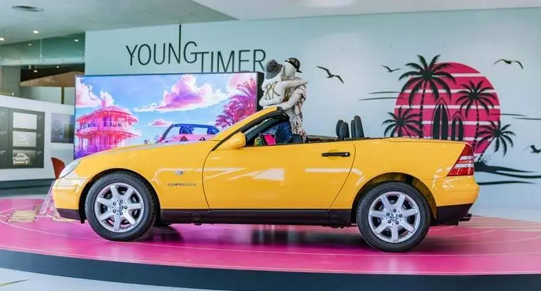Mercedes-Benz SLK 230 Kompressor der Baureihe R 170 in der Lackierung yellowstone (Mercedes-Benz Farbcode 685) aus dem Jahr 1996. Aufnahme von links mit ge&ouml;ffnetem Verdeck in der Sonderausstellung &bdquo;Youngtimer&ldquo; des Mercedes-Benz Museums, 2025. Foto: Thomas Niederm&uuml;ller. (Fotosignatur der Archive von Mercedes-Benz Classic: D854691) 

Mercedes-Benz SLK 230 Kompressor R 170 painted in yellowstone (Mercedes-Benz colour code 685) from the year 1996. Shot from left with open soft top in the special &ldquo;Youngtimer&rdquo; exhibition at the Mercedes-Benz Museum, 2025. Photo: Thomas Niederm&uuml;ller. (Photo index number in the Mercedes-Benz Classic Archives: D854691)