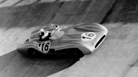 Gro&szlig;er Preis von Italien in Monza, 11. September 1955. Stirling Moss im Mercedes-Benz Formel-1-Rennwagen W 196 R mit Stromlinienkarosserie (Startnummer 16) in der Steilkurve. (Fotosignatur der Mercedes-Benz Classic Archive: R7986) 

Italy Grand Prix at Monza, 11 September 1955. Stirling Moss in the Mercedes-Benz W 196 R Formula One racing car with a streamlined body (starting number 16) in the banked corner. (Photo signature of the Mercedes-Benz Classic Archive: R7986)