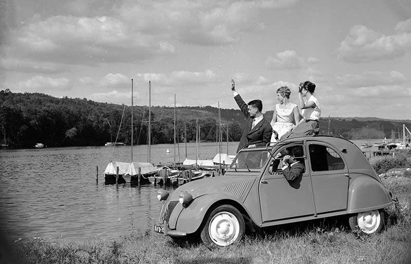 Europe, France, Œle-de-France, Yvelines, Meulan-en-Yvelines. Femmes et hommes dans et en dehors d'une 2CV stationnÈe le long du port en 1956. Utilisation Èditoriale uniquement, nous contacter pour toute autre utilisation
