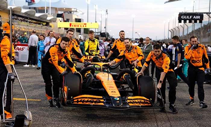 BAHRAIN INTERNATIONAL CIRCUIT, BAHRAIN - MARCH 02: Mechanics bring Lando Norris, McLaren MCL38, to the grid during the Bahrain GP at Bahrain International Circuit on Saturday March 02, 2024 in Sakhir, Bahrain. (Photo by Steven Tee / LAT Images)