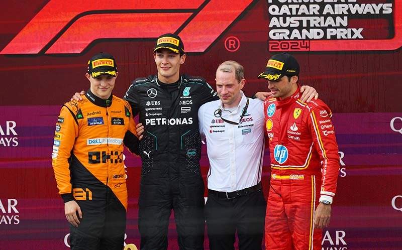 RED BULL RING, AUSTRIA - JUNE 30: Oscar Piastri, McLaren F1 Team, 2nd position, George Russell, Mercedes-AMG F1 Team, 1st position, the Mercedes trophy delegate and Carlos Sainz, Scuderia Ferrari, 3rd position, on the podium during the Austrian GP at Red Bull Ring on Sunday June 30, 2024 in Spielberg, Austria. (Photo by Mark Sutton / LAT Images)