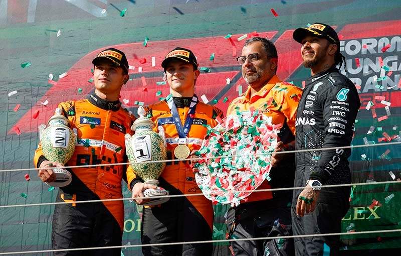 HUNGARORING, HUNGARY - JULY 21: Lando Norris, McLaren F1 Team, 2nd position, Oscar Piastri, McLaren F1 Team, 1st position, the McLaren trophy delegate and Sir Lewis Hamilton, Mercedes-AMG F1 Team, 3rd position, on the podium during the Hungarian GP at Hungaroring on Sunday July 21, 2024 in Budapest, Hungary. (Photo by Glenn Dunbar / LAT Images)