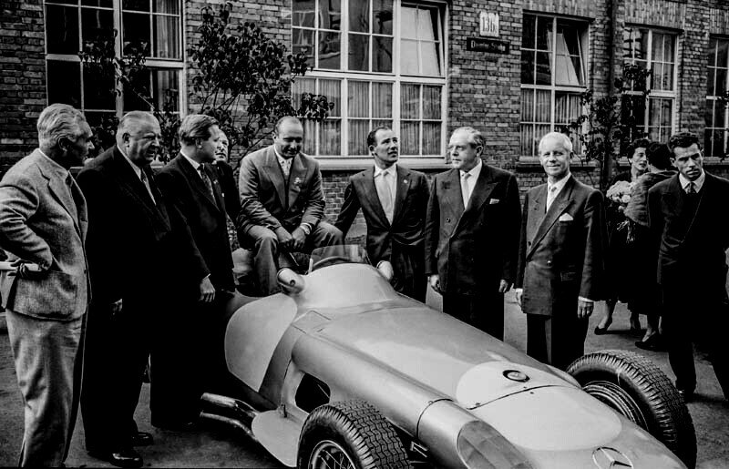 Abschlussfeier der Rennsaison 1955 im Mercedes-Benz Werk Untertürkheim am 24. Oktober 1955. Von links nach rechts am Mercedes-Benz Formel 1-Rennwagen W 196 R: Piero Taruffi, Rennleiter Alfred Neubauer, Werner Engel, Karl Kling (verdeckt), Juan Manuel Fangio, Stirling Moss, Dr. Hermann Veit (Wirtschaftsminister von Baden-Württemberg), Fritz Nallinger und André Simon. (Fotosignatur der Archive von Mercedes-Benz Classic: 55299-18) 

Closing ceremony of the 1955 racing season at the Mercedes-Benz plant in Untertürkheim on 24 October 1955. From left to right with the Mercedes-Benz W 196 R Formula 1 racing car: Piero Taruffi, race director Alfred Neubauer, Werner Engel, Karl Kling (hidden), Juan Manuel Fangio, Stirling Moss, Dr Hermann Veit (Minister of Economic Affairs of Baden-Württemberg), Fritz Nallinger and André Simon. (Photo index number in the Mercedes-Benz Classic Archive: 55299-18)