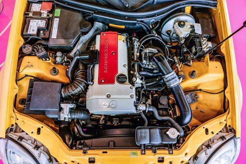 Mercedes-Benz SLK 230 Kompressor der Baureihe R 170 in der Lackierung yellowstone (Mercedes-Benz Farbcode 685) aus dem Jahr 1996. Detailaufnahme des Motorraums in der Sonderausstellung „Youngtimer“ des Mercedes-Benz Museums, 2025. Foto: Thomas Niedermüller. (Fotosignatur der Archive von Mercedes-Benz Classic: D854680) 

Mercedes-Benz SLK 230 Kompressor R 170 painted in yellowstone (Mercedes-Benz colour code 685) from the year 1996. Detailed view of the engine compartment in the special “Youngtimer” exhibition at the Mercedes-Benz Museum, 2025. Photo: Thomas Niedermüller. (Photo index number in the Mercedes-Benz Classic Archives: D854680)
